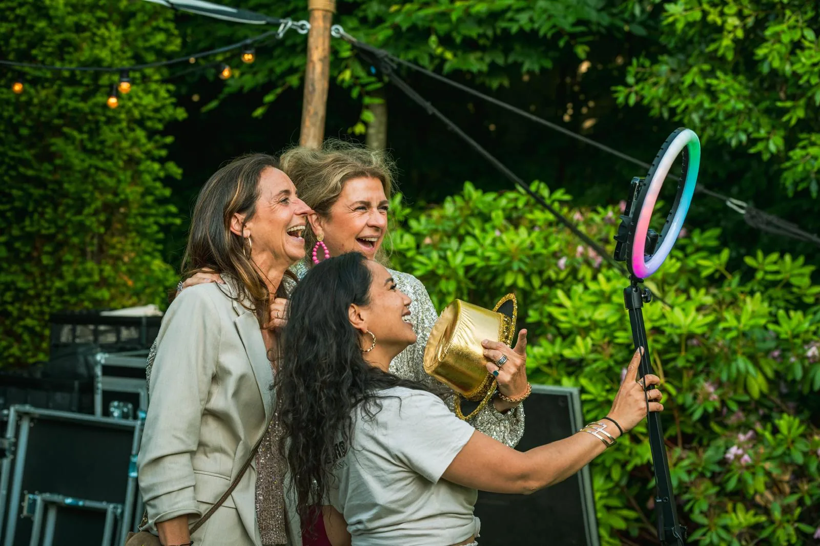 Drie vriendinnen lachend bij ringlight tijdens bruiloft