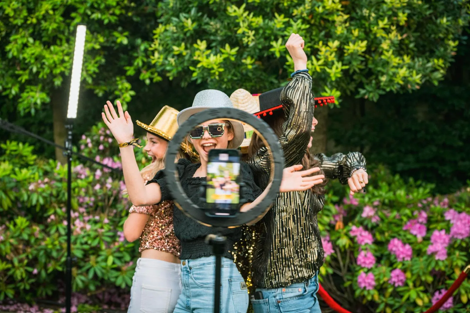 Vrolijke gasten met hoeden bij 360 videobooth tuinfeest